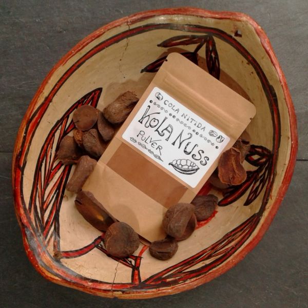 Eine kleine packung Kolanusspackung mit getrockneten Kolanüssen in einer afrikanischen Schale